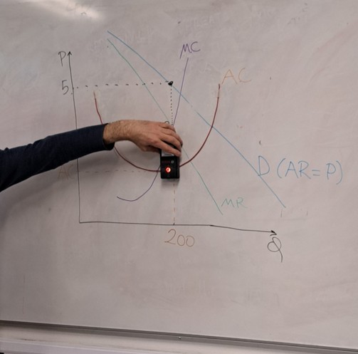 Photograph showing a wire detector placed on top of the U-shaped wire with its light on, showing that it detects the wire